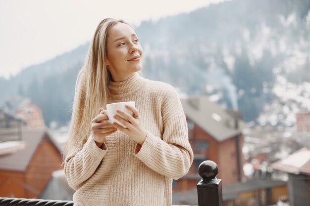 Meisje in een warme lichte jas. Vakantie in de bergen. Dame met lang haar.