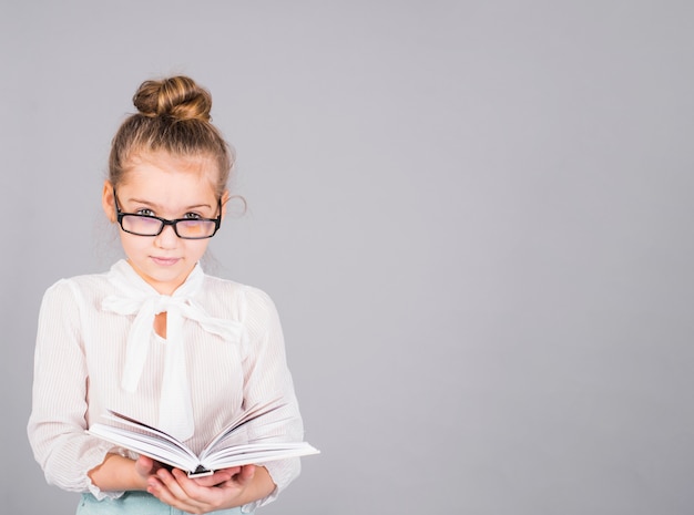 Meisje in glazen die zich met boek bevinden