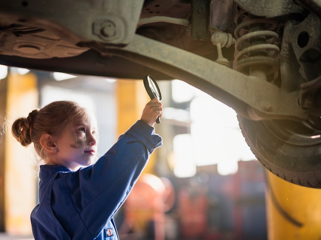 Meisje in het algemene inspecteren van auto met meer magnifier