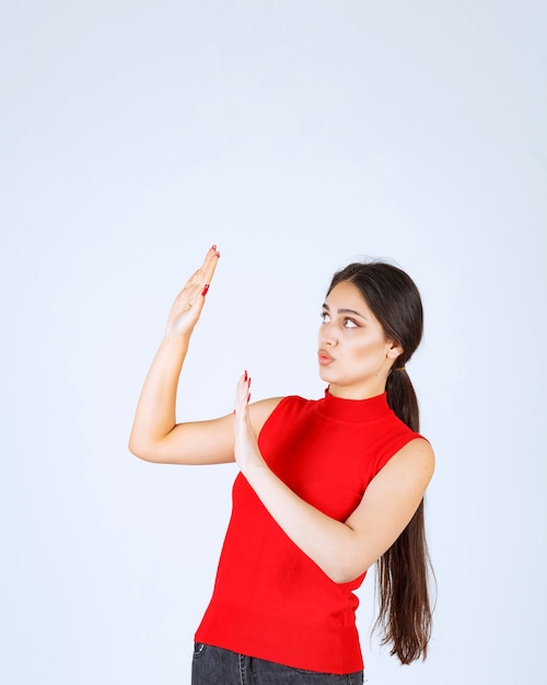 Meisje in rood overhemd dat iemand tegenhoudt.