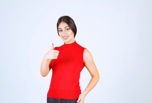 Meisje in rood shirt duimen opdagen.