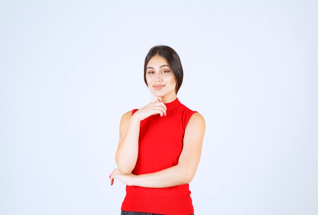 Meisje in rood shirt geeft mooie en verleidelijke poses.