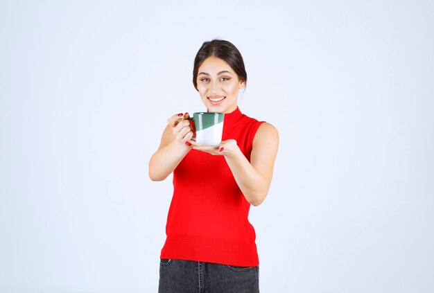 Meisje in rood shirt met een koffiemok.