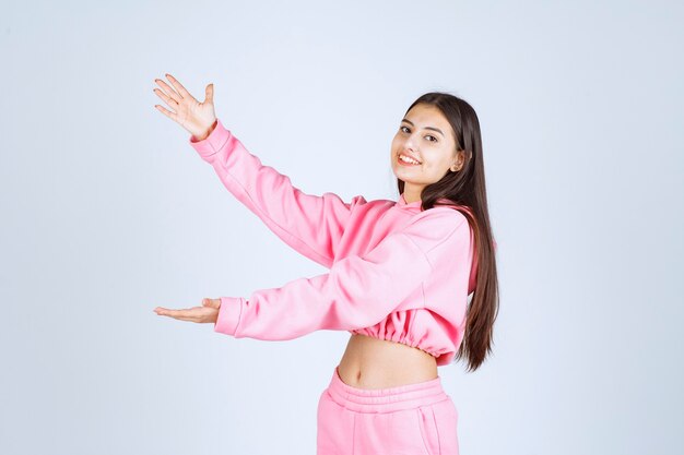 Meisje in roze pyjama met de grootte van een voorwerp