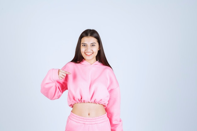 Meisje in roze pyjama's die positieve en vervelende houdingen geven