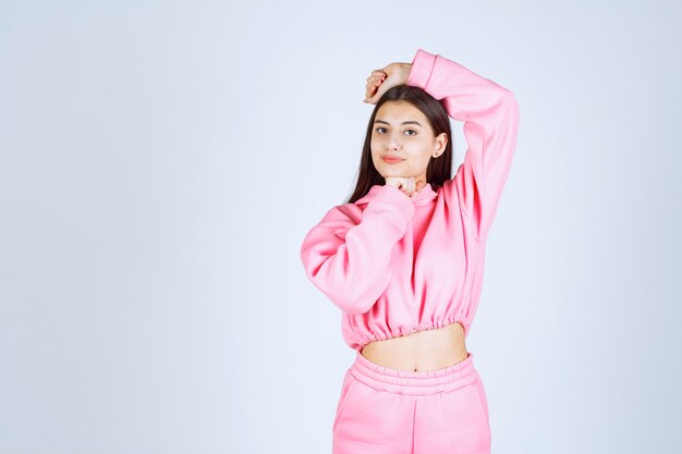 Meisje in roze pyjama's die positieve en vervelende houdingen geven