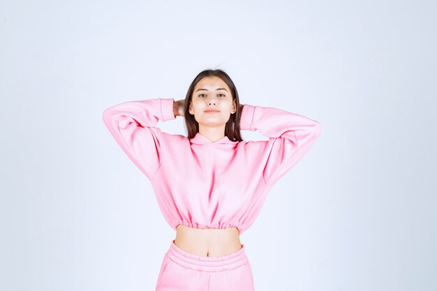 Meisje in roze pyjama's die positieve en vervelende houdingen geven