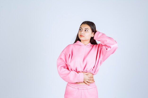 Meisje in roze pyjama's die vervelende en vrolijke poses geven