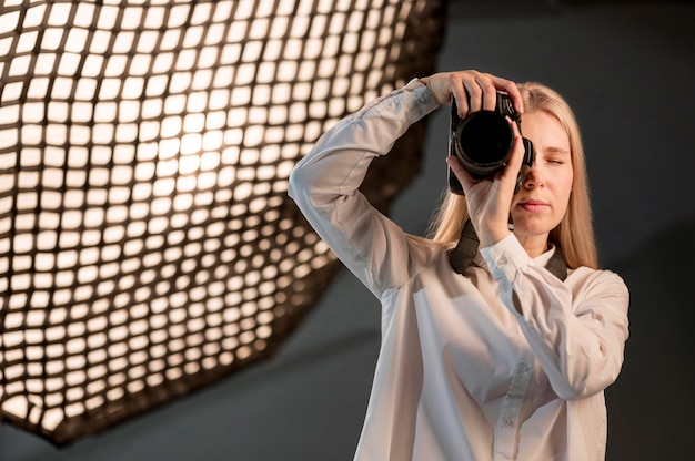 Meisje in studio die een foto met camera neemt