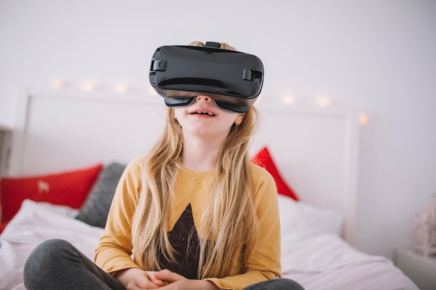 Meisje in VR-beschermende brillen op bed