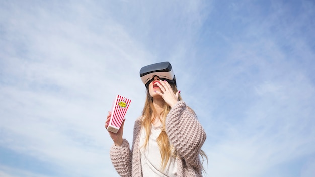 Meisje in VR-hoofdtelefoon met popcorn