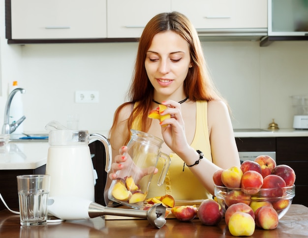 Meisje koken drankjes van perziken op de keuken