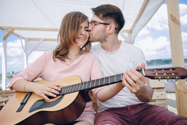 Meisje krijgt een kus tijdens het spelen van de gitaar