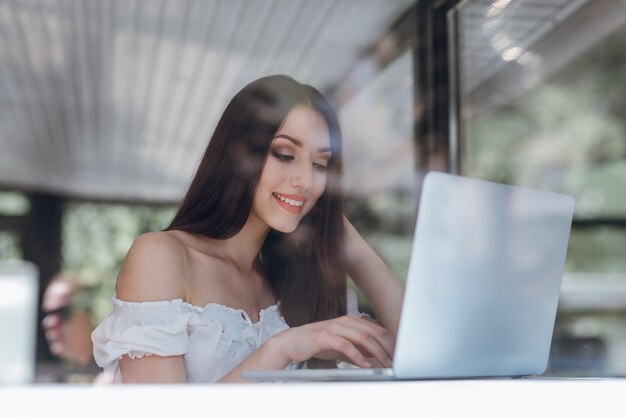 Meisje lacht typen op een laptop
