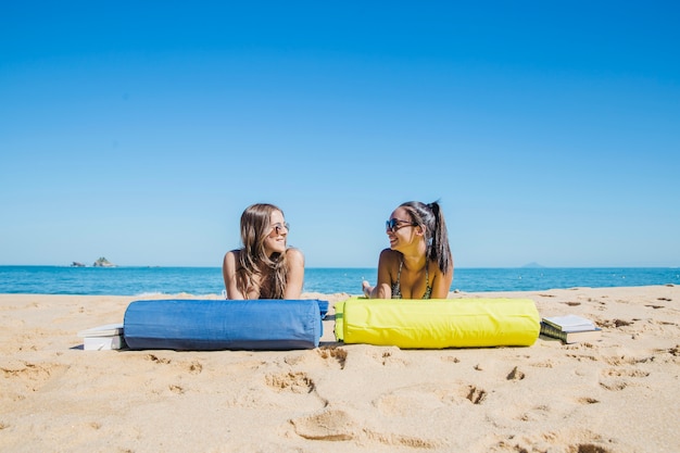 Gratis foto meisje liggend op het strand naar elkaar kijken