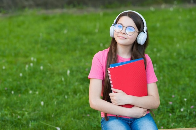 Meisje luisteren zomer melodie draadloze hoofdtelefoon natuur achtergrond hobby en vrije tijd concept Premium Foto