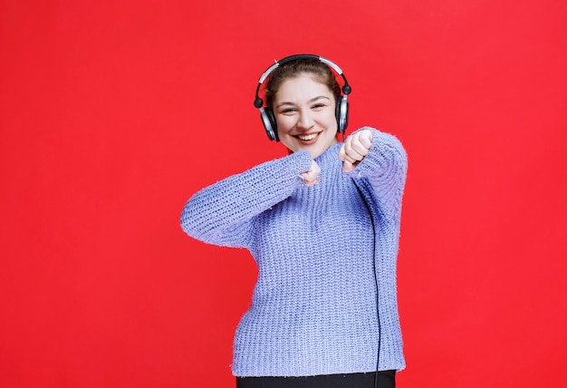 Meisje luistert naar de muziek op haar koptelefoon en heeft plezier.