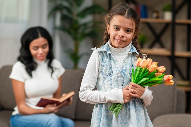 Gratis foto meisje met bloemen voor haar moeder