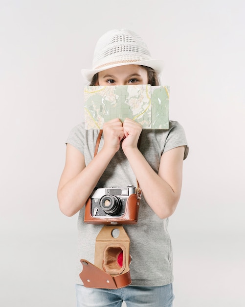 Meisje met camera en kaart in studio