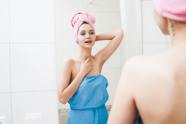 Meisje met een handdoek op haar hoofd die zichzelf in de spiegel bekijkt
