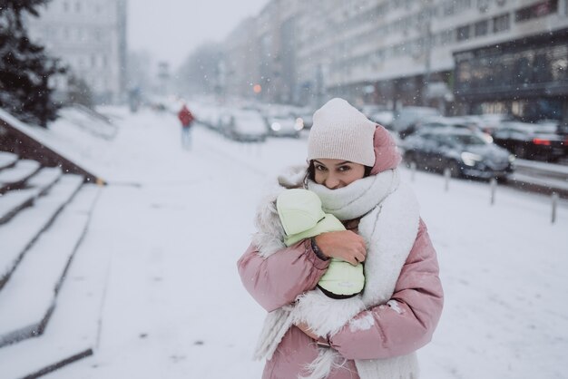 Meisje met een hond in haar armen valt sneeuw