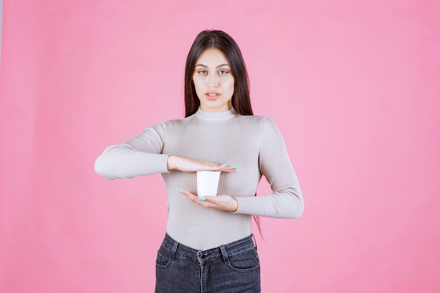 Meisje met een koffiekopje tussen haar handen