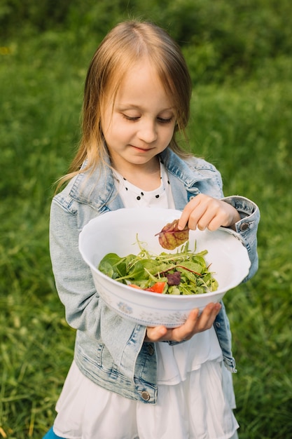 Meisje met een salade in de natuur