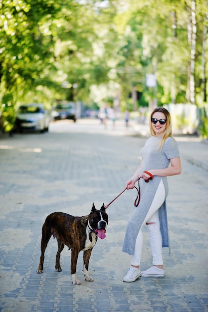 Meisje met hond pitbullterriër op een wandeling