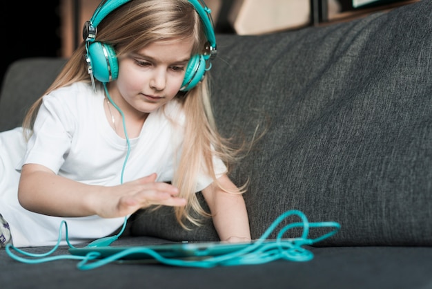 Meisje met hoofdtelefoons en tablet