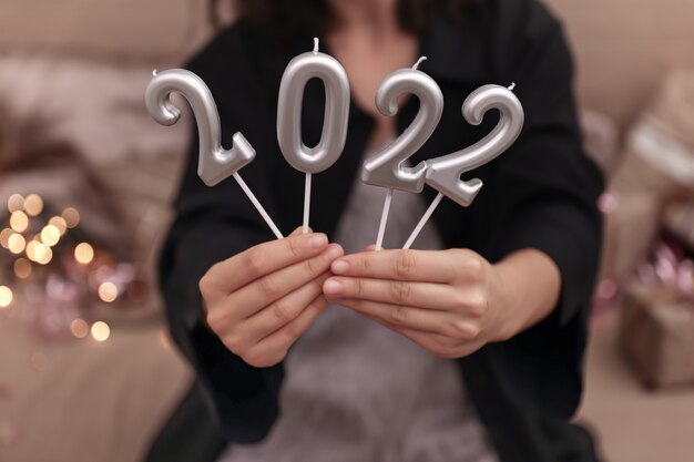 Meisje met kaarsen in de vorm van nummers 2022, nieuwjaarsviering concept.