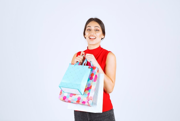 Meisje met kleurrijke boodschappentassen voelt zich positief.
