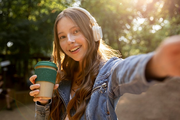 Gratis foto meisje met koptelefoon luisteren muziek buiten