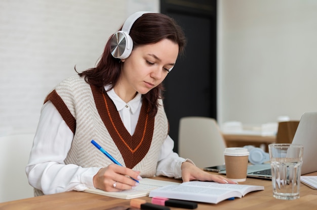 Meisje met koptelefoon tijdens groepsstudie