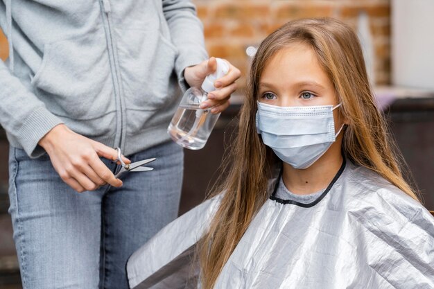 Meisje met medisch masker bij de kapper