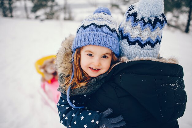 Meisje met moeder het spelen in een de winterpark