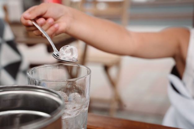 Gratis foto meisje met moeder spelen met ijsblokjes in een gezellig café. goede relatie tussen ouders en kind. gelukkige momenten samen