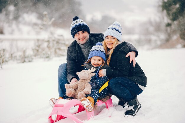 Meisje met ouders die in een de winterpark spelen