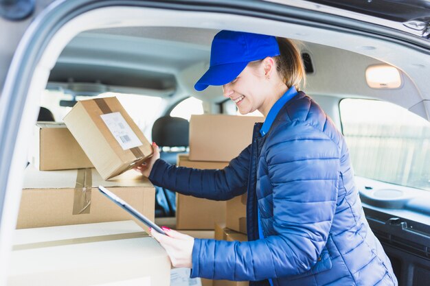 Meisje met tablet en dozen in auto