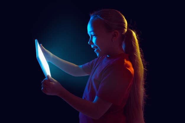 Meisje met tablet in neonlicht