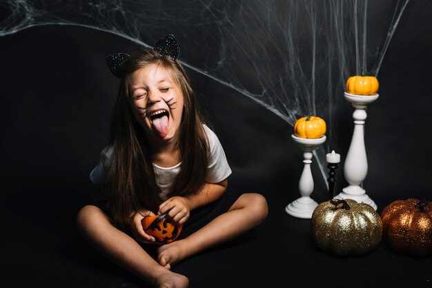 Meisje met trick or treat mand in de buurt van Halloween decoraties