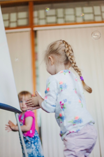 Gratis foto meisje met vlecht die zeepbellen vangt