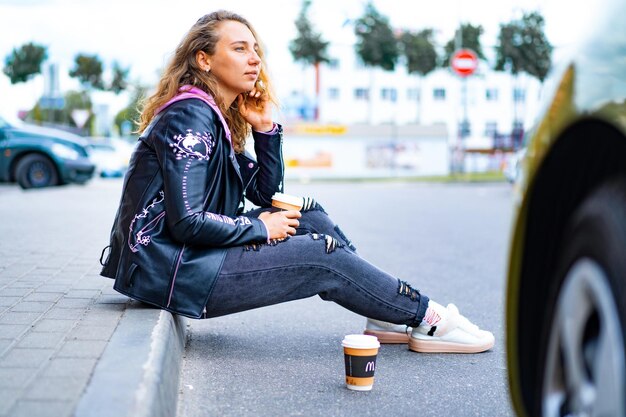 meisje met wit krullend haar met een glas koffie.