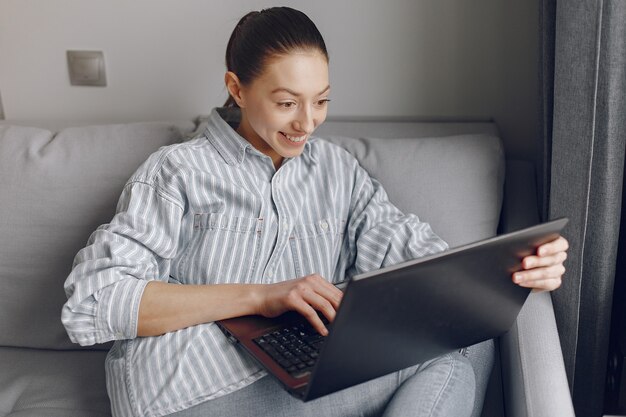 Meisje om thuis te zitten en de laptop te gebruiken