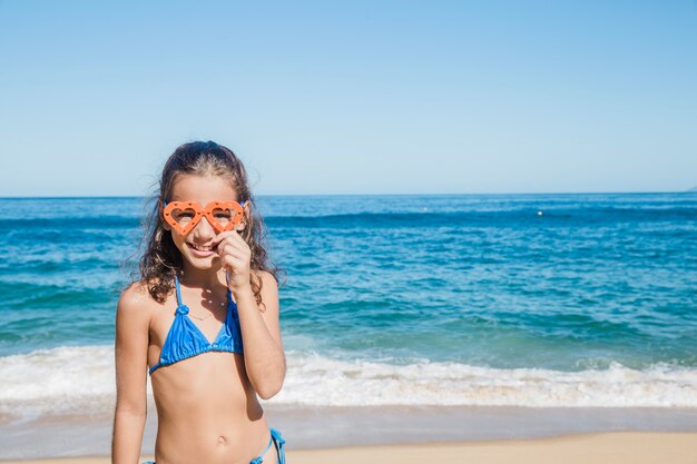 Meisje op het strand blij met haar bril