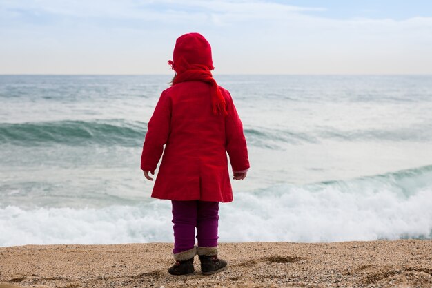 Meisje op het strand in winderige dag