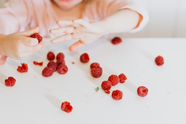 Gratis foto meisje speelt met framboos