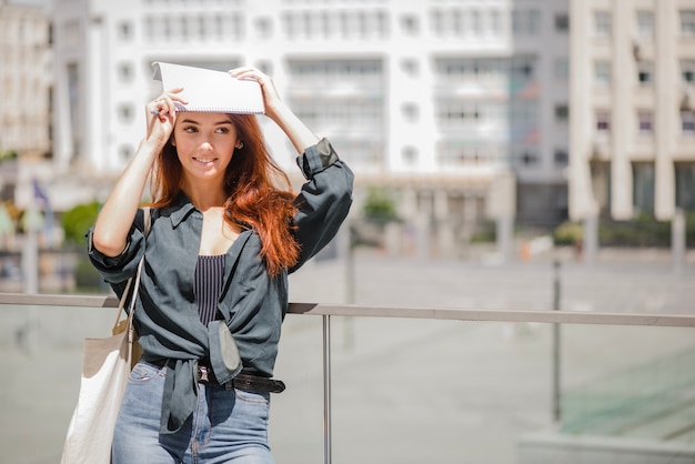 Gratis foto meisje staande hoofdhoofd met notitieboekje