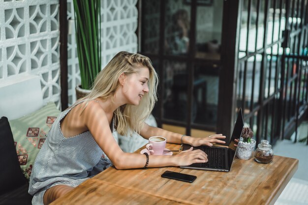 meisje werkt in een café. concept van freelancen, koffie en laptop.