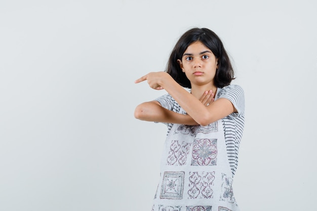 Meisje wijst naar de linkerkant in t-shirt