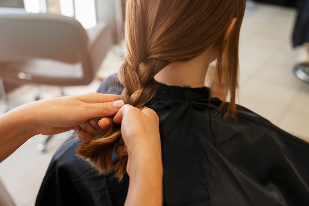 Meisje wordt gestyled in een hoge hoek van de salon